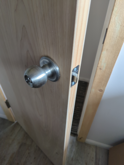 photo of the bathroom door with a shiny new doorknob