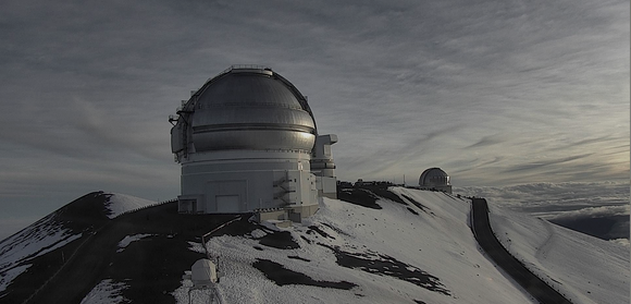 photo of the observatories at the top of Maunakea with melting snow.