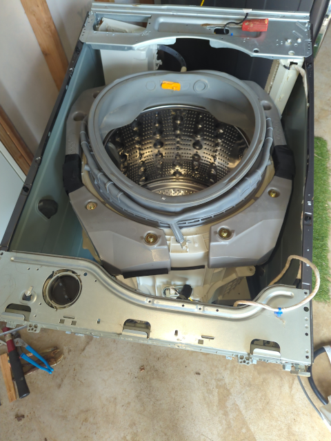 photo of an LG front-loading washer on its back with the front panel removed