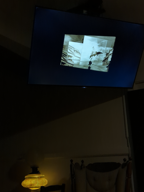 photograph of a ceiling-mounted television showing an intro to a movie