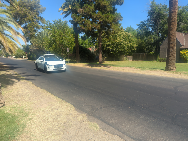 photo of a Waymo autonomous vehicle driving down a residential street