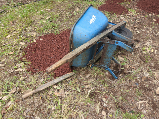 photo of the wheelbarrow on its side with cinder spilling out and a broken handle